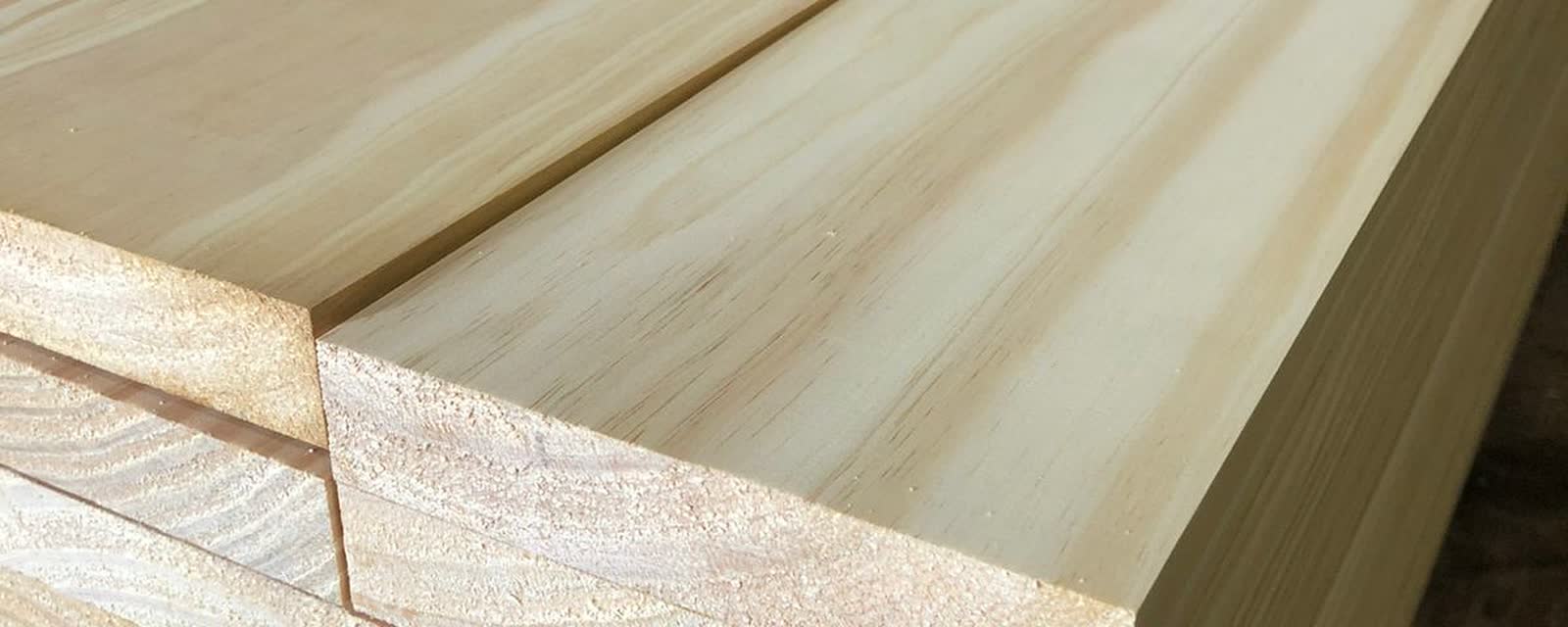 Close-up of stacked knot-free pine boards freshly milled at a South American sawmill, showing the clean grain used for premium grading